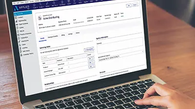 An open laptop with the screen on the Applied Epic website with a hand on the keyboard in the bottom right corner